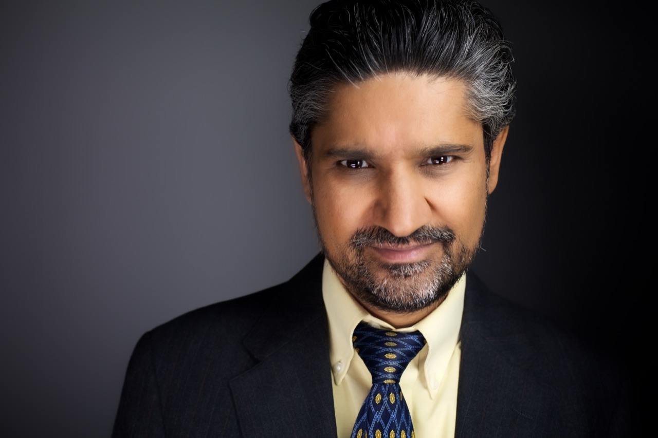 Close-up studio portrait of Kuldip Korotana in a dark suit