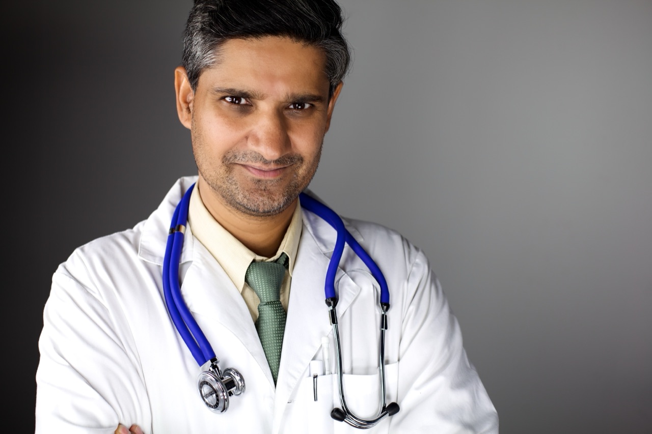 Kuldip Korotana in a white doctor coat with a stethoscope