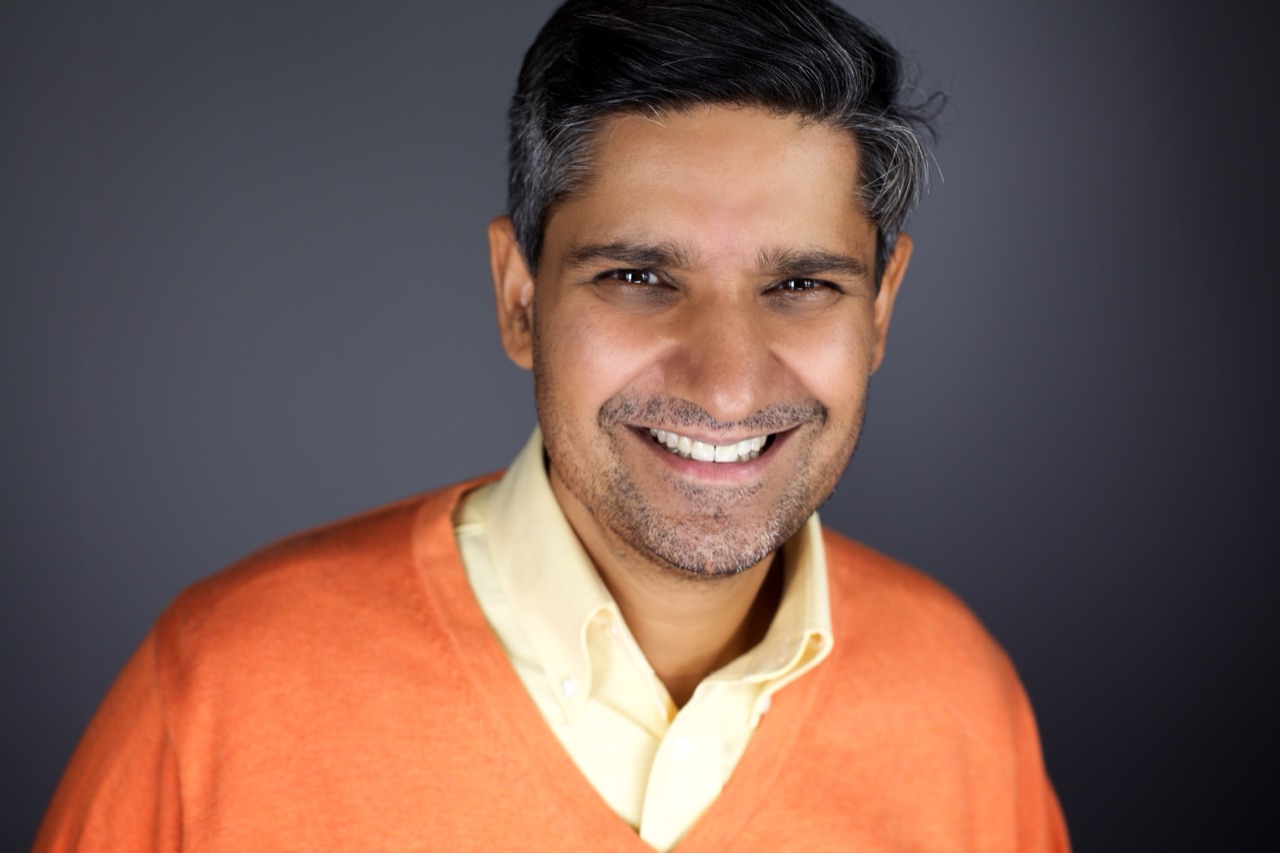 Kuldip Korotana smiling in an orange sweater