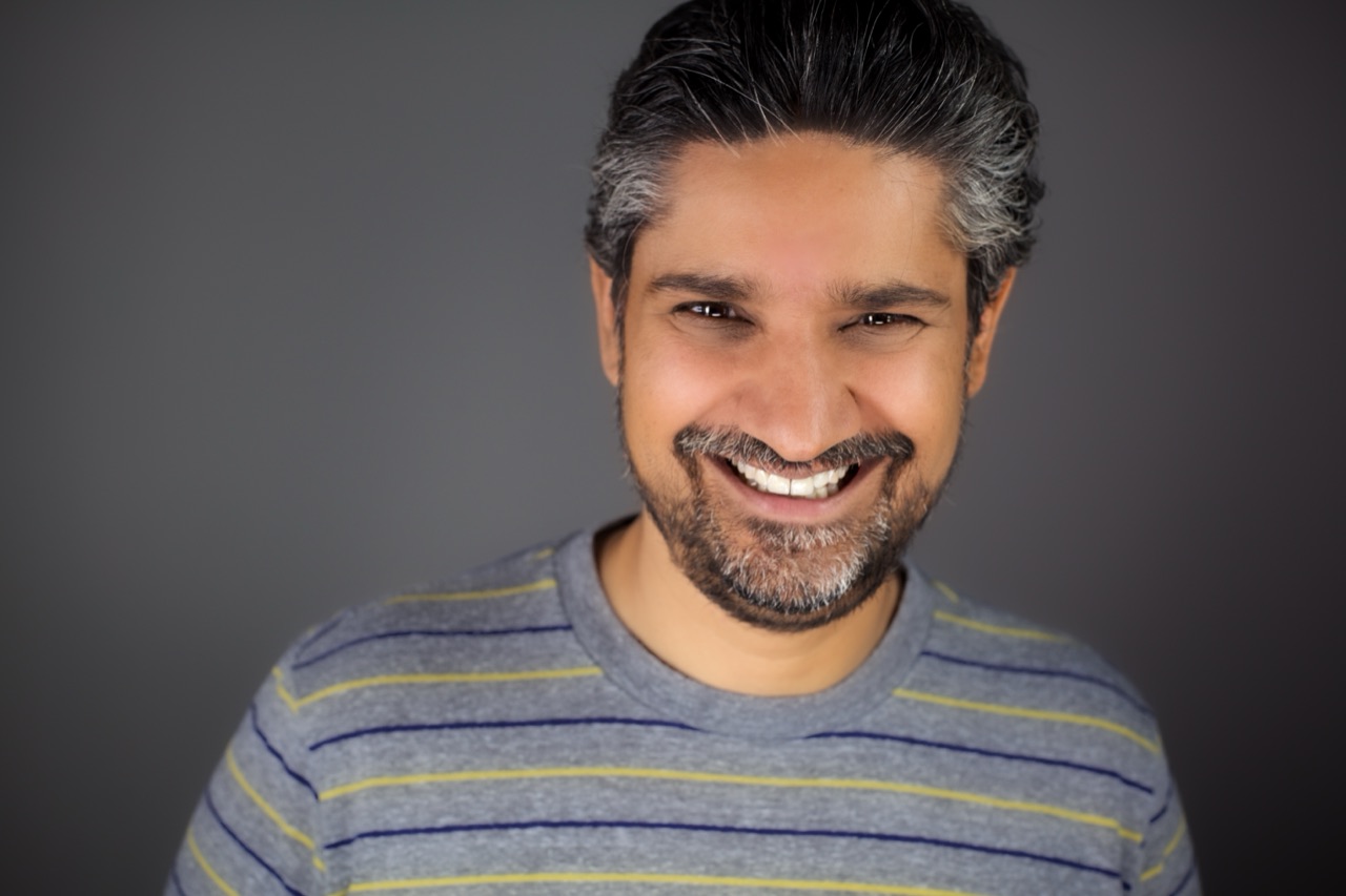Casual headshot of Kuldip Korotana in a grey striped shirt